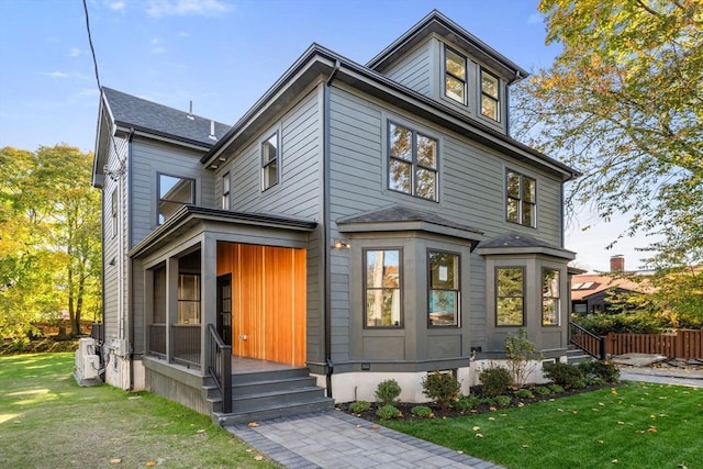 american foursquare style home with a front lawn