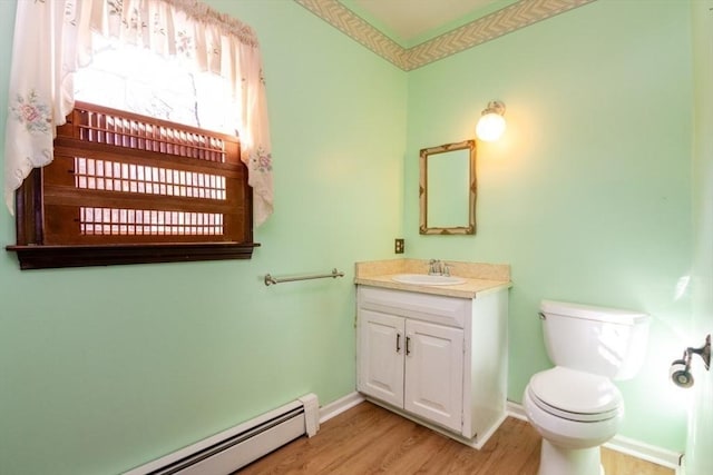 bathroom with hardwood / wood-style flooring, vanity, toilet, and a baseboard heating unit