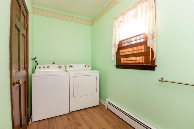 laundry room with a baseboard radiator, light wood-type flooring, and washer and clothes dryer