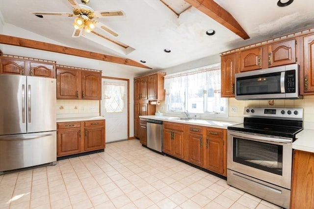 kitchen featuring stainless steel appliances, sink, decorative backsplash, and lofted ceiling with beams