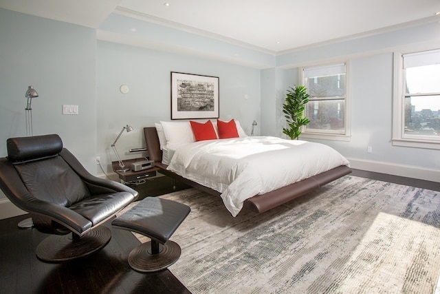 bedroom with multiple windows, wood-type flooring, and crown molding