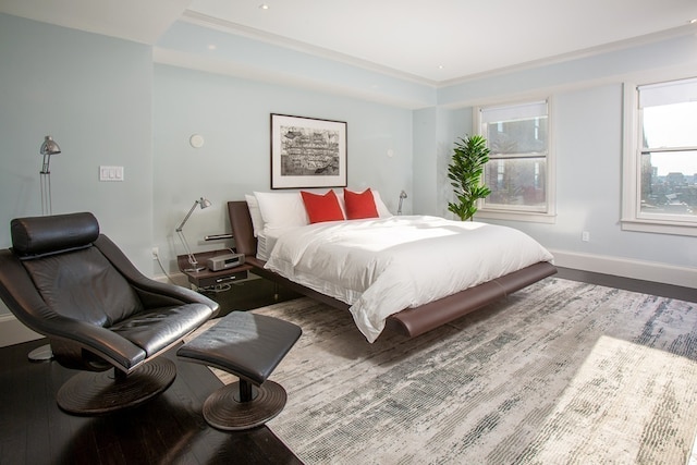 bedroom featuring baseboards, wood finished floors, and ornamental molding
