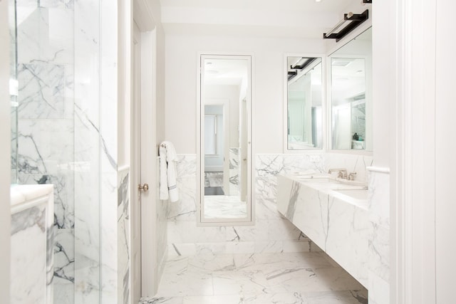 full bathroom featuring marble finish floor, wainscoting, vanity, and tile walls
