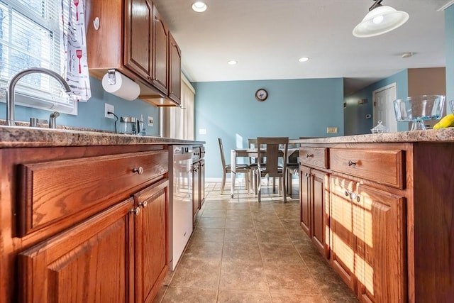 kitchen with light tile patterned floors, dishwasher, and decorative light fixtures