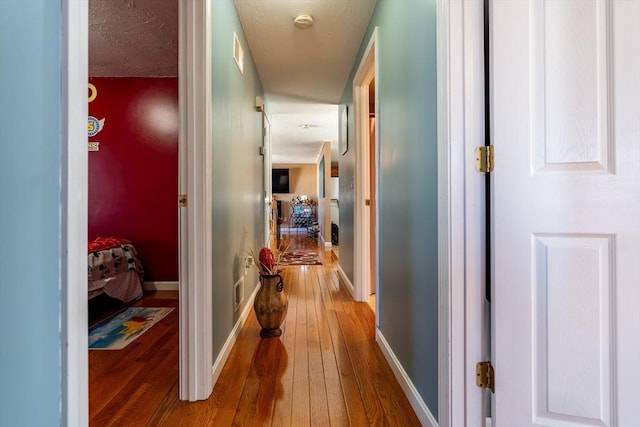 hallway with hardwood / wood-style floors