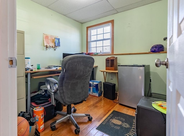 office space with a drop ceiling and light hardwood / wood-style flooring