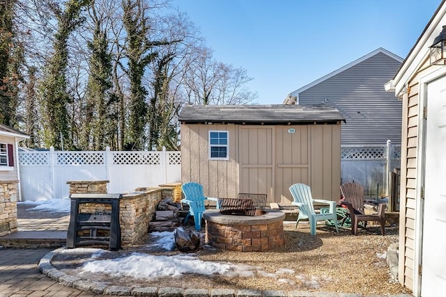 view of patio featuring a shed, a fire pit, and exterior bar