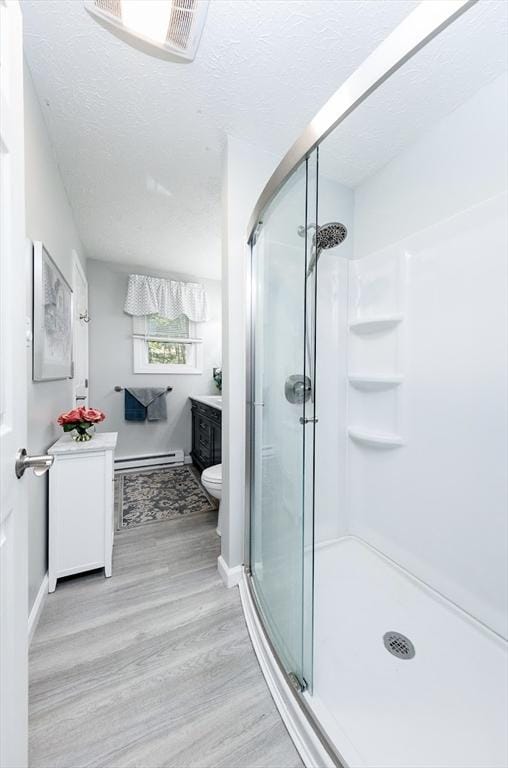 171 David Cir, Putnam, CT 06260 - full bathroom with vanity, a stall shower, wood finished floors, baseboard heating, and a textured ceiling
