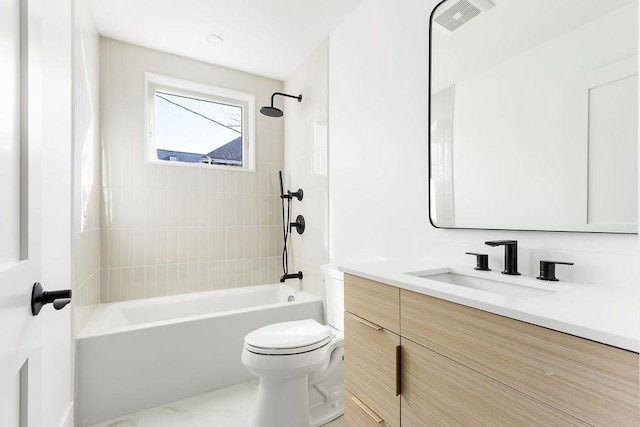 full bathroom with tiled shower / bath, vanity, and toilet