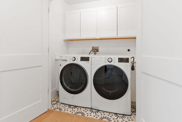 laundry room featuring washing machine and dryer and cabinets