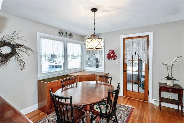 dining area with light wood-type flooring and baseboards