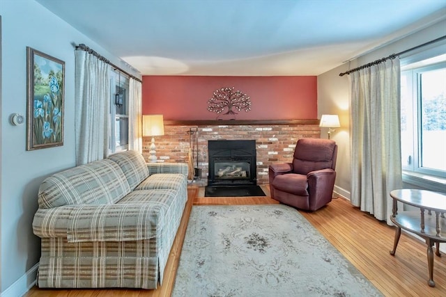 sitting room featuring a fireplace, baseboards, and wood finished floors