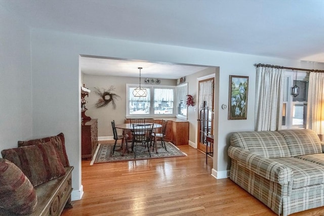 dining space with light wood finished floors and baseboards