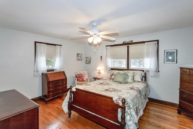 bedroom with a ceiling fan, baseboards, and wood finished floors