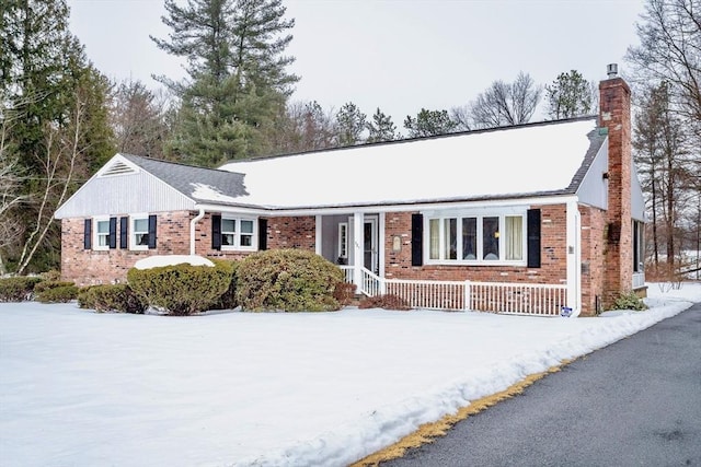 ranch-style home featuring a chimney and brick siding