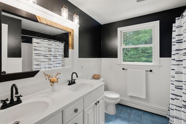 85 Green Meadow Ct, Northbridge, MA 01588 - full bathroom featuring baseboard heating, a wainscoted wall, toilet, double vanity, and tile patterned flooring