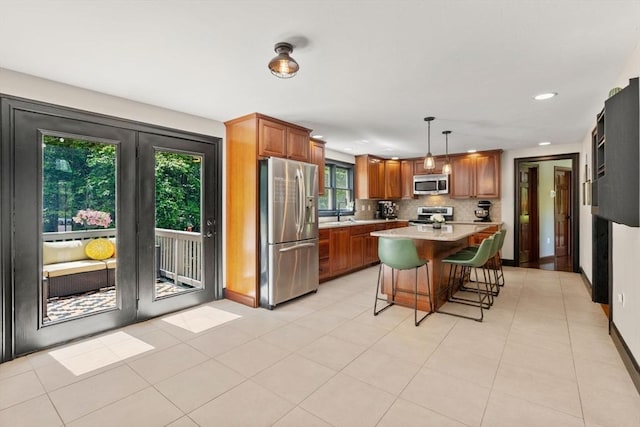 85 Green Meadow Ct, Northbridge, MA 01588 - kitchen with stainless steel appliances, light countertops, brown cabinets, a kitchen breakfast bar, and recessed lighting