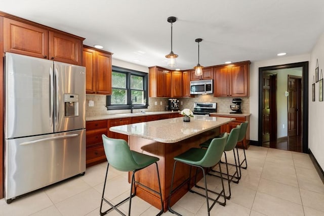 85 Green Meadow Ct, Northbridge, MA 01588 - kitchen with appliances with stainless steel finishes, tasteful backsplash, light tile patterned flooring, decorative light fixtures, and a center island