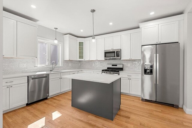 13 River St Unit 1, Danvers, MA 01923 - kitchen with light countertops, appliances with stainless steel finishes, white cabinetry, and a sink