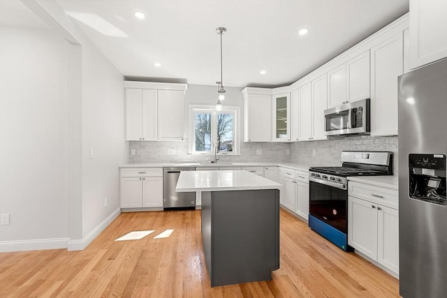 13 River St Unit 1, Danvers, MA 01923 - kitchen with light countertops, a sink, a kitchen island, tasteful backsplash, and appliances with stainless steel finishes