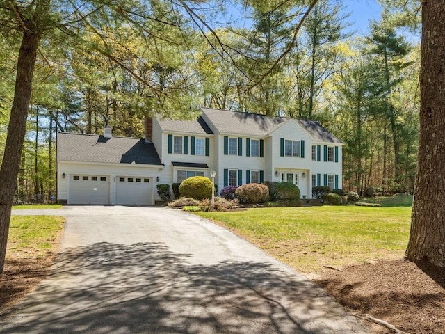 8 Kennedy Ln, Acton, MA 01720 - colonial inspired home featuring asphalt driveway, a garage, a chimney, and a front lawn