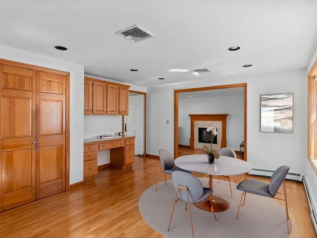 8 Kennedy Ln, Acton, MA 01720 - dining area with light wood-style flooring, recessed lighting, a tiled fireplace, baseboards, and baseboard heating