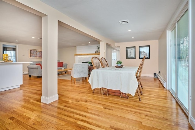 dining space with recessed lighting, a baseboard heating unit, light wood finished floors, and visible vents