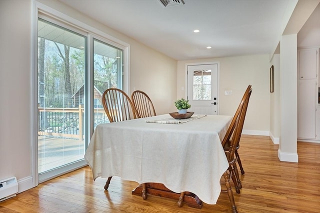 dining space featuring baseboards, a baseboard radiator, and light wood-style flooring