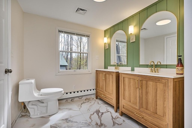 bathroom with visible vents, two vanities, a baseboard radiator, toilet, and marble finish floor