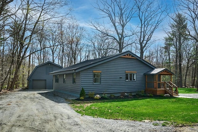 view of home's exterior with a garage, an outbuilding, a yard, driveway, and metal roof