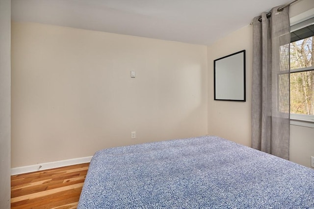 bedroom featuring baseboards and wood finished floors