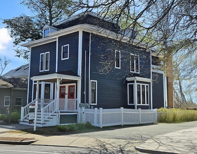 view of front facade with french doors and a fenced front yard