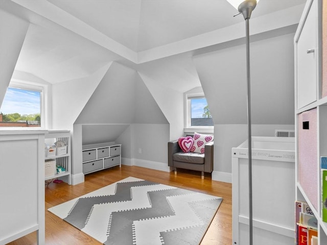 bedroom featuring baseboards, vaulted ceiling, and wood finished floors
