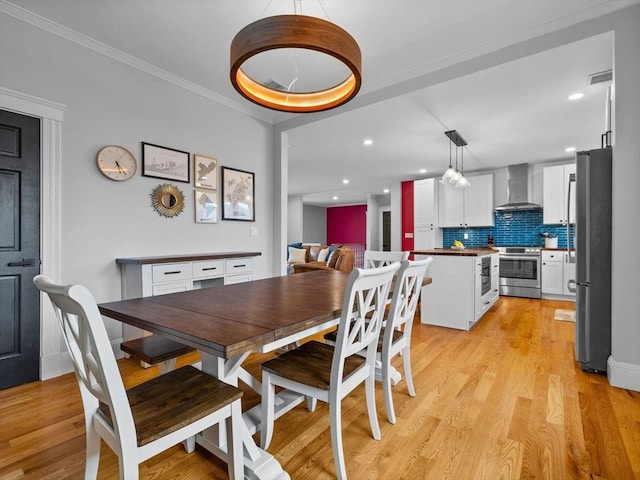 dining room with ornamental molding, recessed lighting, light wood-style flooring, and visible vents
