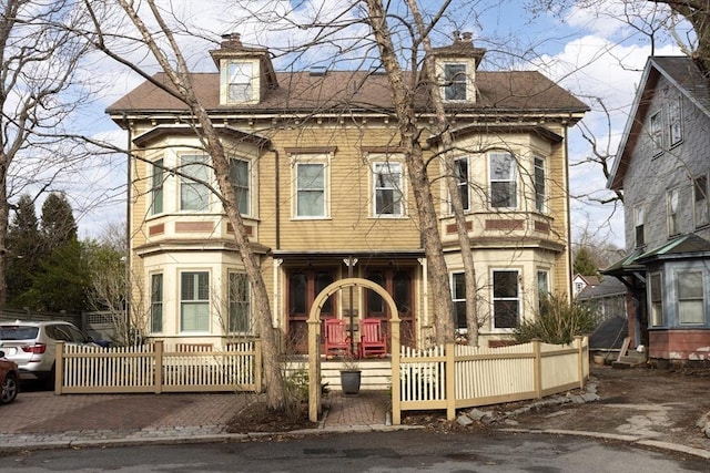 view of front facade with a fenced front yard and a chimney