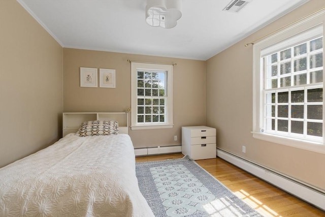 217 Conant Rd, Weston, MA 02493 - bedroom featuring baseboard heating, wood finished floors, and ornamental molding