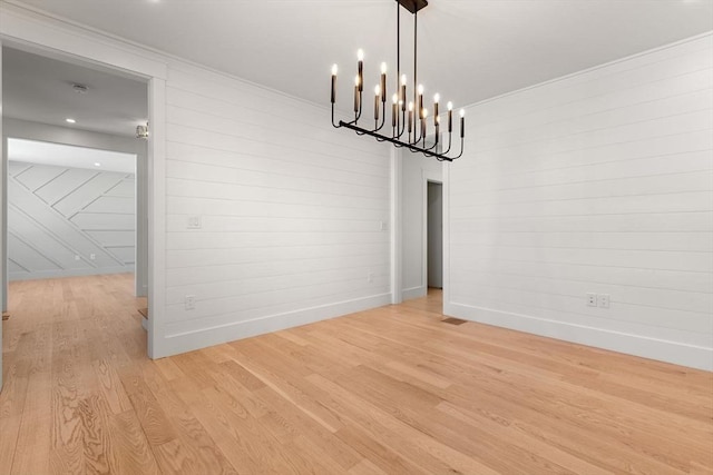 unfurnished dining area with light hardwood / wood-style flooring and a notable chandelier