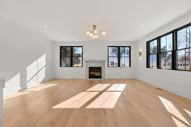 unfurnished living room with light hardwood / wood-style flooring and a wealth of natural light