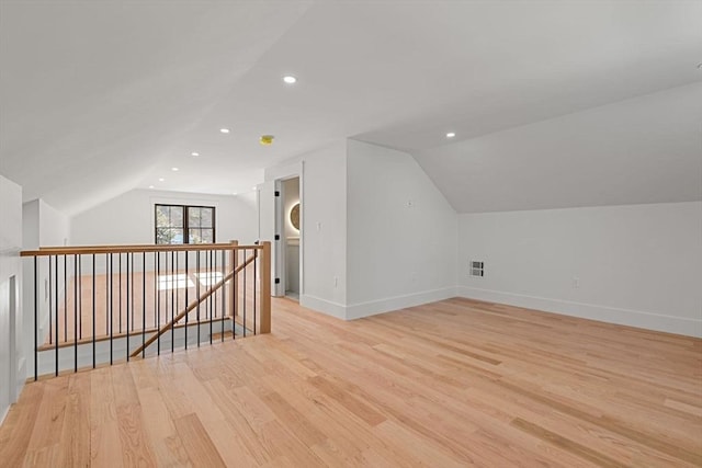 bonus room featuring light wood-type flooring and vaulted ceiling