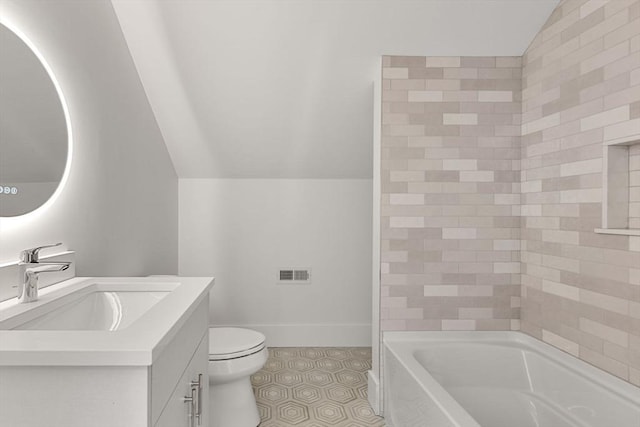 bathroom featuring vanity, a bathtub, vaulted ceiling, and toilet