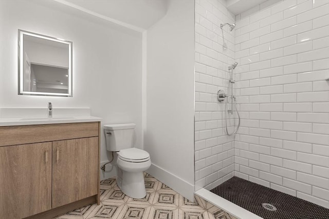 bathroom featuring vanity, toilet, and tiled shower