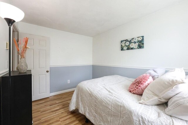bedroom featuring baseboards and wood finished floors
