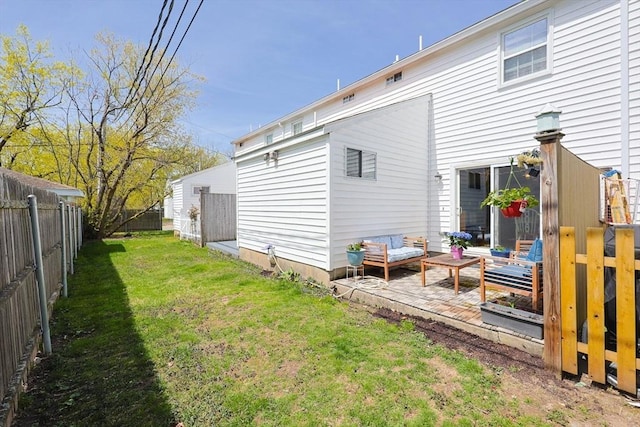 back of house with a fenced backyard, a patio, an outdoor hangout area, and a lawn
