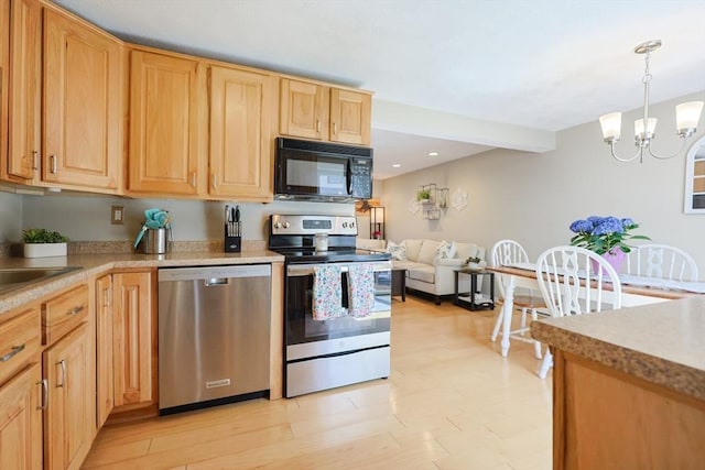kitchen featuring an inviting chandelier, light countertops, light brown cabinets, and stainless steel appliances