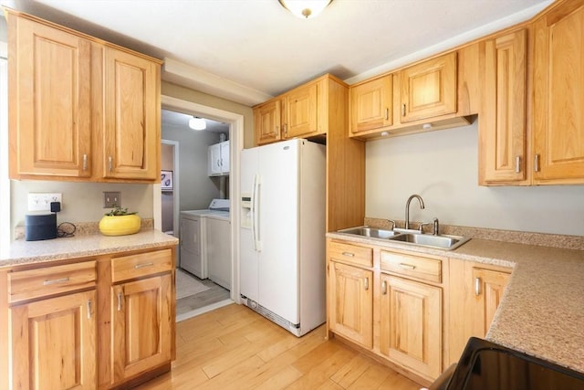 kitchen with a sink, light countertops, separate washer and dryer, white fridge with ice dispenser, and light wood-type flooring