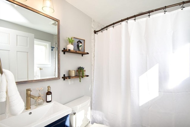 bathroom featuring a shower with curtain, vanity, and toilet