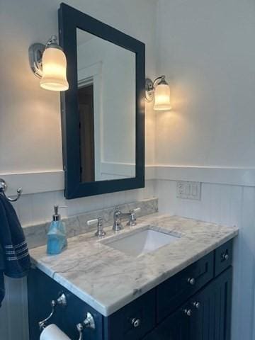 bathroom featuring a wainscoted wall and vanity