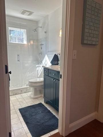 bathroom with toilet, a stall shower, visible vents, and vanity