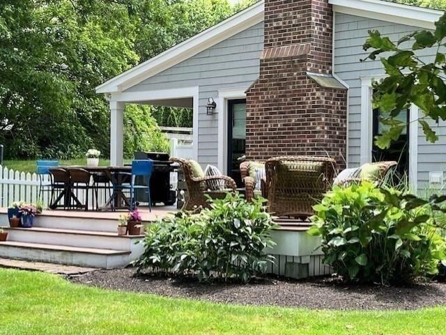 back of property with fence and a chimney