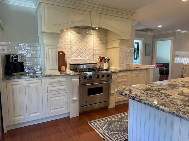 kitchen with dark wood finished floors, designer stove, light stone countertops, crown molding, and white cabinetry